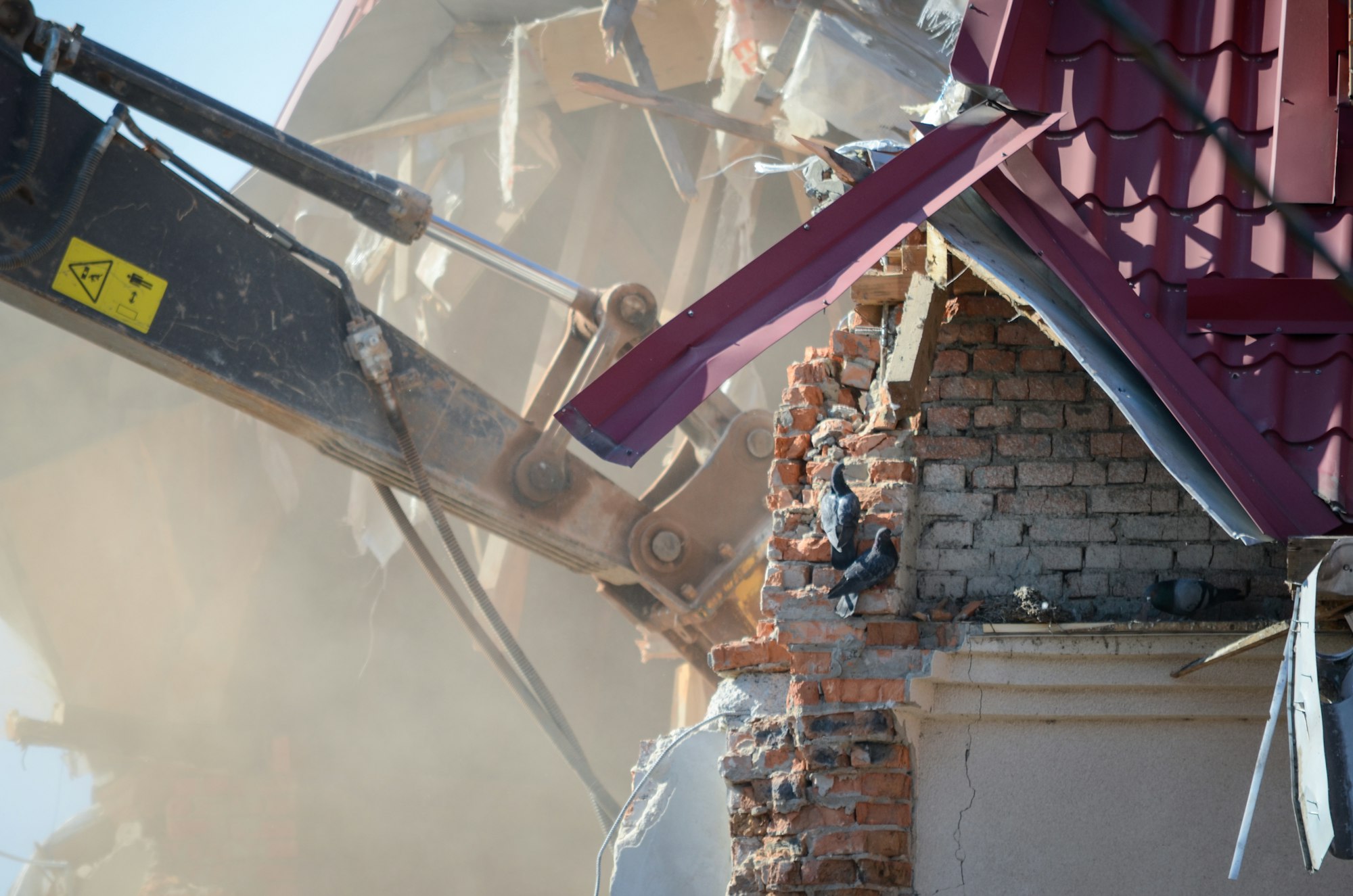 Excavator destroys a house. Building reconstruction. Engineering work.